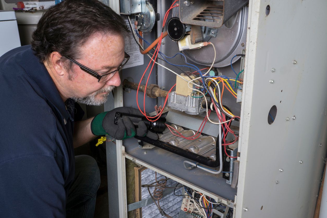 HVAC technician tuning up gas furnace